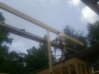 Carpenter setting a ridge beam over a new addition frame — Ice Dam Removal by Roofing Brothers in Winsted