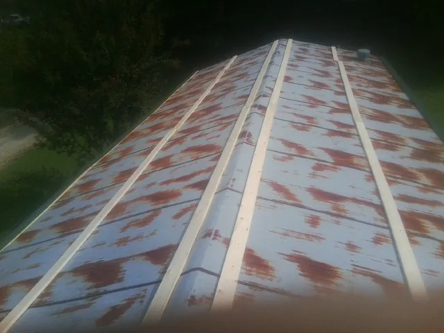 Rusted metal roof panels with new wood purlins before replacement — Storm Damage Roof Repair in Winsted by Roofing Brothers