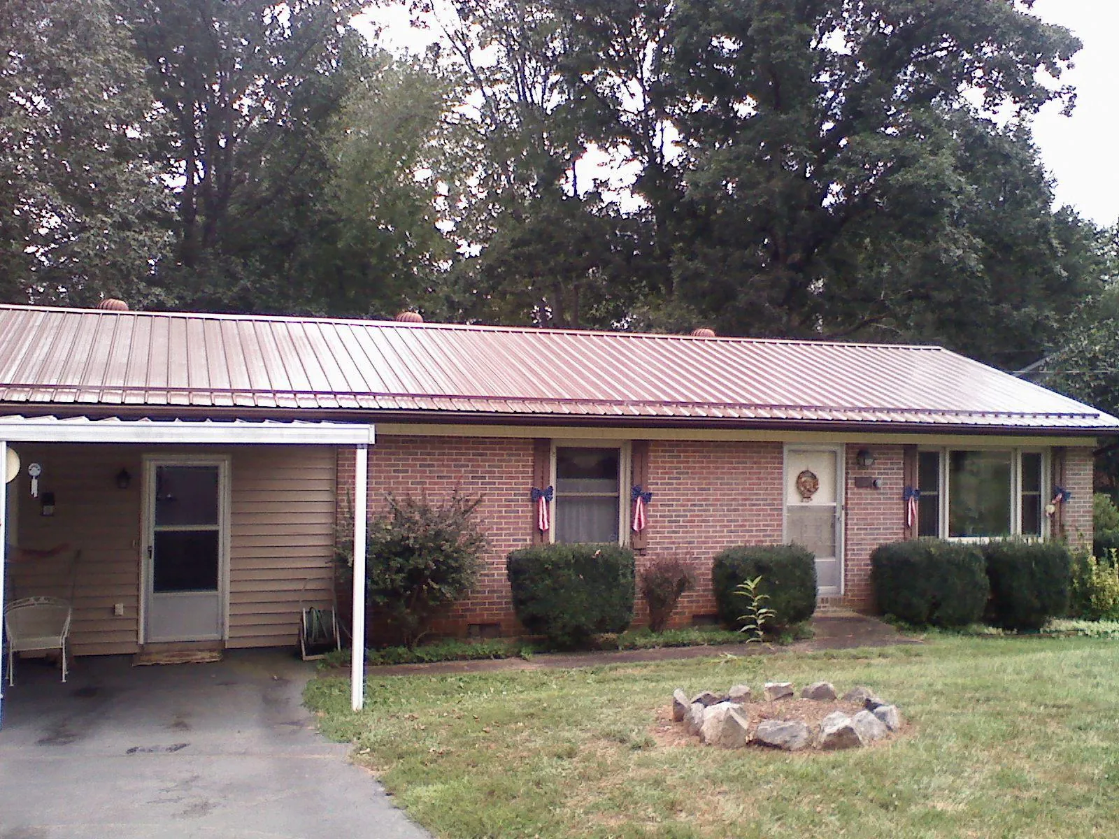 Bronze metal roof and carport on a brick ranch home — Roof Repair work by our crew in Winsted